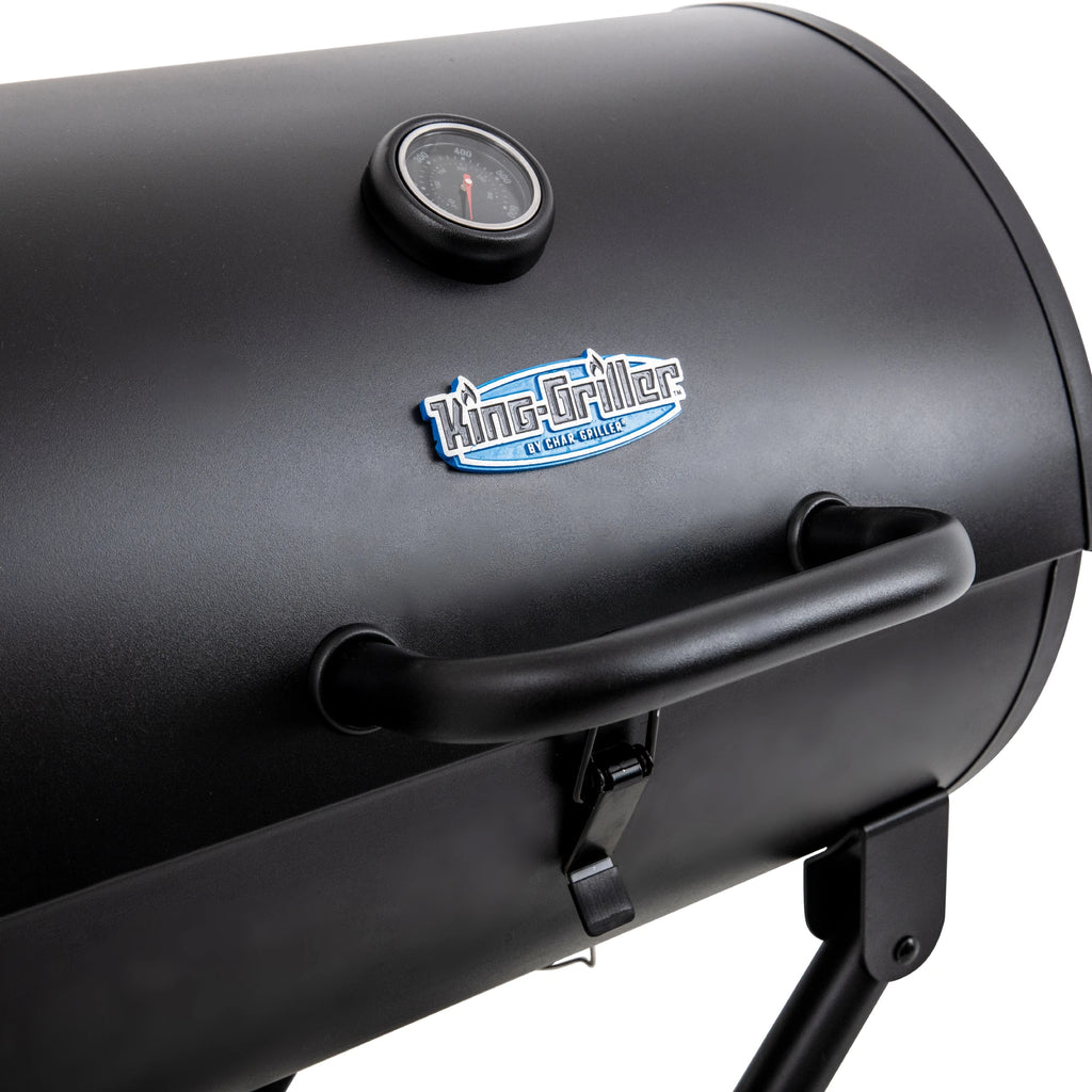 Black barrel barbecue grill with a King-Griller logo plate and a temperature gauge built into the lid. The lid has a handle, and a latch securely holds the lid closed.