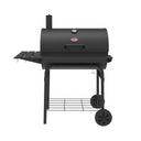 Black barrel grill on a cart with a side shelf on the left and a narrow shelf across the front. The grill is on a cart with 2 wheels and a wire shelf near the bottom. The grill lid has a smokestack on the left, built-in temperature gauge, and handle.