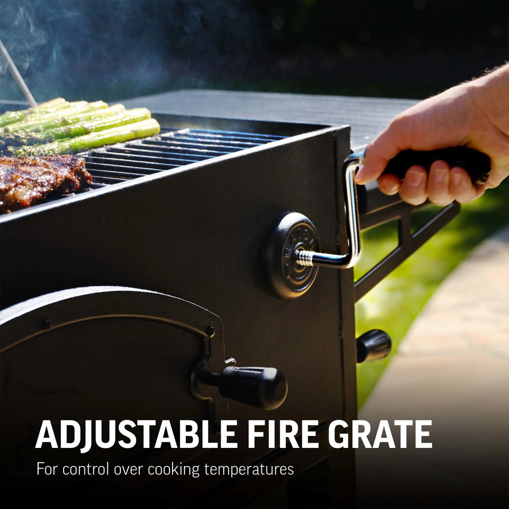 Person using the crank handle mounted in the body of the grill to adjust the fire grate height. Text reads: Adjustable fire grate for control over cooking temperatures.
