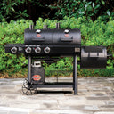 Closed Texas Trio barbecue grill with side burner on a patio with greenery in the background