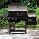 Open Texas Trio barbecue grill with multiple burners and a side shelf on a paved patio with greenery in the background.