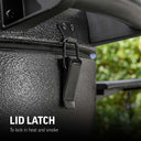 Extreme closeup of the metal latch holding the grill dome locked onto the body. Text reads: Lid latch to lock in heat and smoke.
