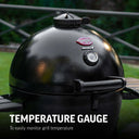 Closed black AKORN grill with a temperature gauge built into the lid just below Char-Griller and AKORN logo plates and above the lid handle. Text reads: Temperature Gauge to easily monitor grill temperature.