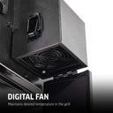 View of the digital fan mounted outside of the base of the charcoal hopper. The hinged access door hangs open so the fan is visible. Text overlay reads: Digital Fan maintains desired temperature in the grill.