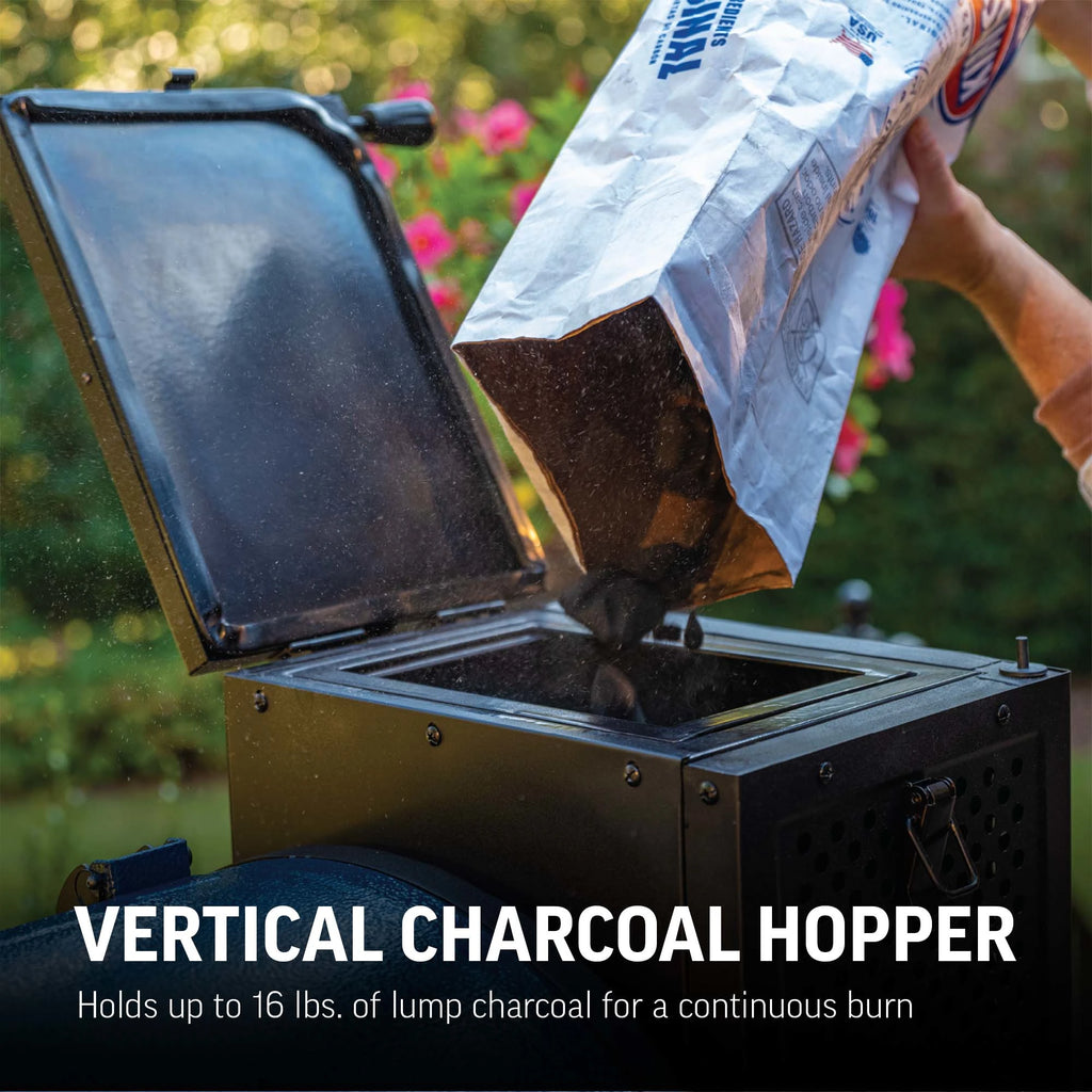 Person loading charcoal into a vertical charcoal hopper with text highlighting capacity and use. Text reads: Vertical charcoal hopper holds up to 16 lbs. of lump charcoal for a continuous burn.