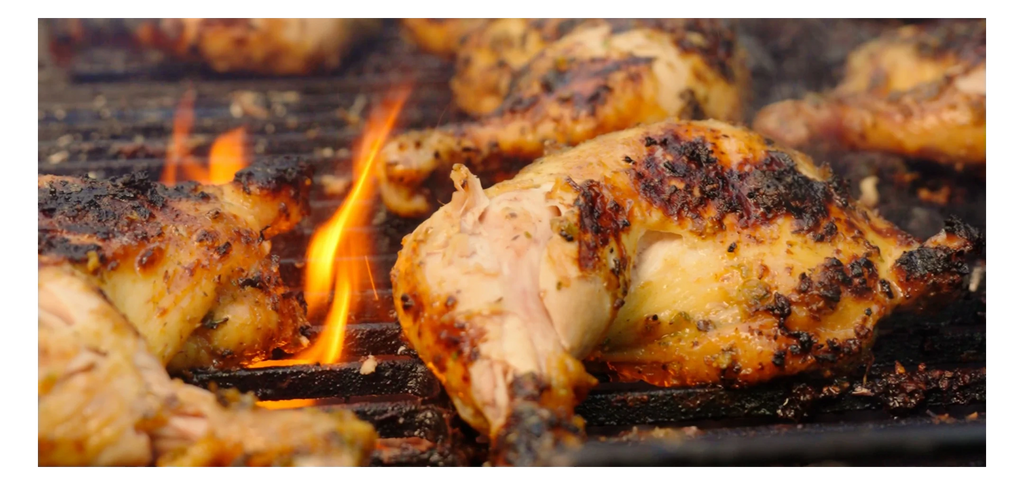 Grilled chicken on a barbecue with flames