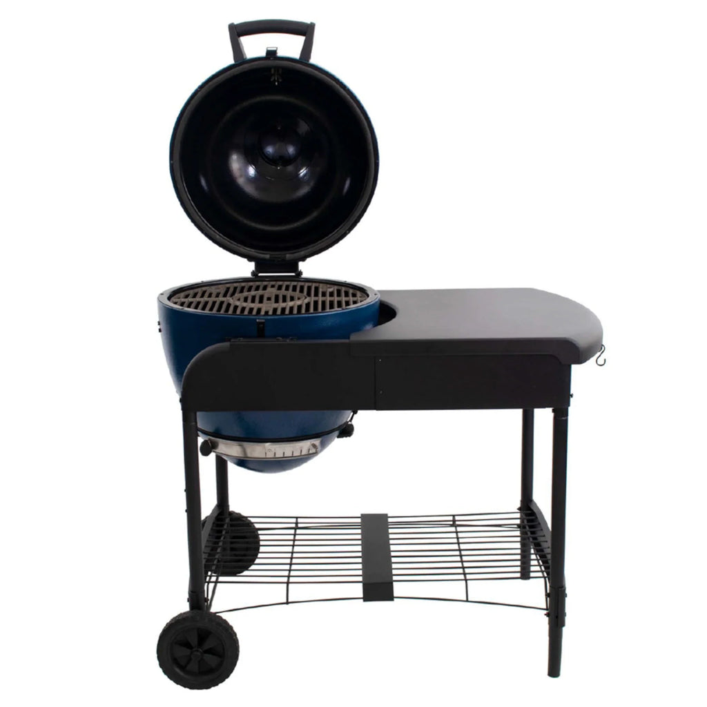 The Akorn grill mounted in the cart with the grill hood open to show the cast iron cooking grates.