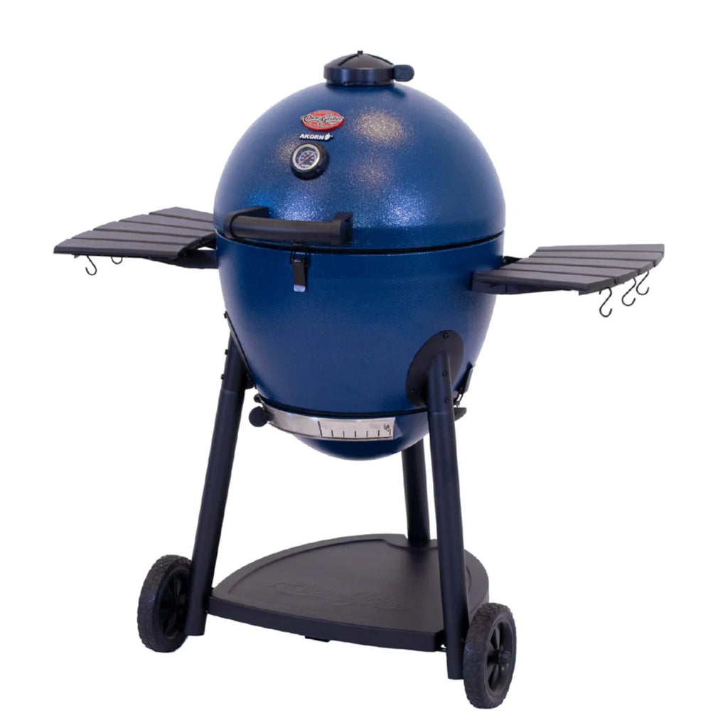 A sapphire blue kamado-style grill on a black metal cart with wheels, shown on a plain white background. The grill has side shelves with hanging hooks and a temperature gauge on the front.