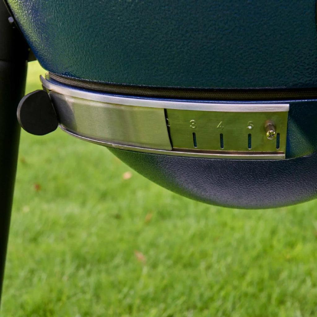 Close-up of the bottom damper mounted on the EasyDump ash tray at the bottom of a blue AKORN grill.