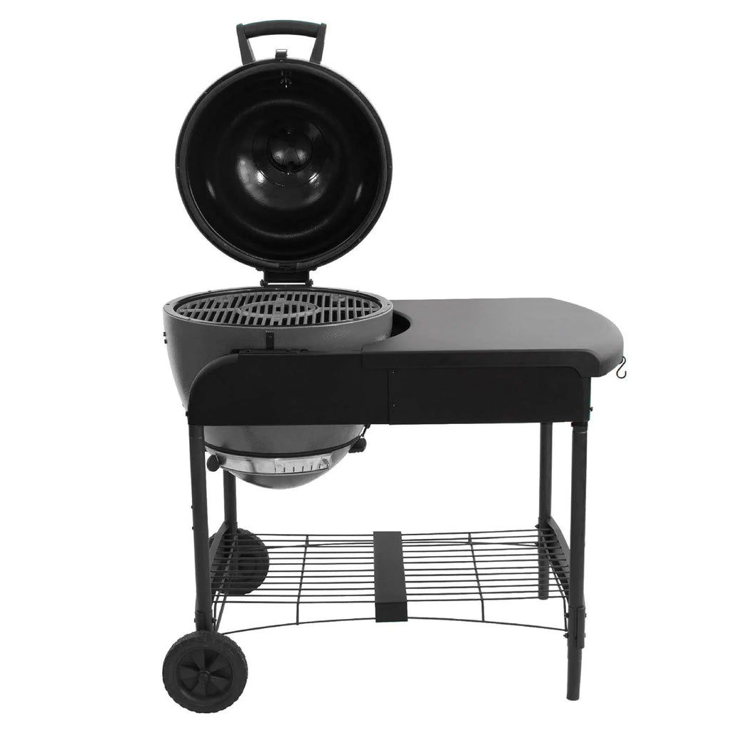 The Akorn grill mounted in the cart with the grill hood open to show the cast iron cooking grates.