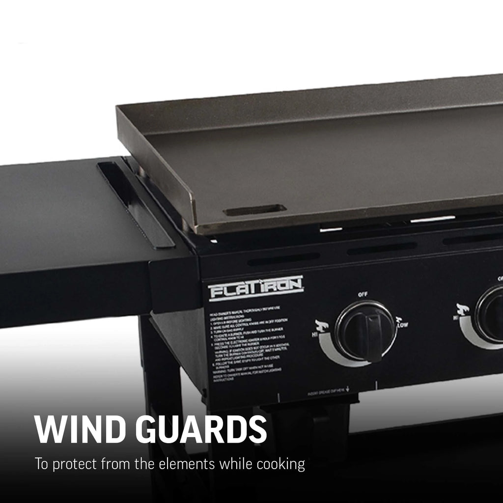 Closeup of half the griddle area showing a wall about 2 inches tall around side and back of griddle cooking surface. Text reads: wind guards to protect from the elements while cooking.